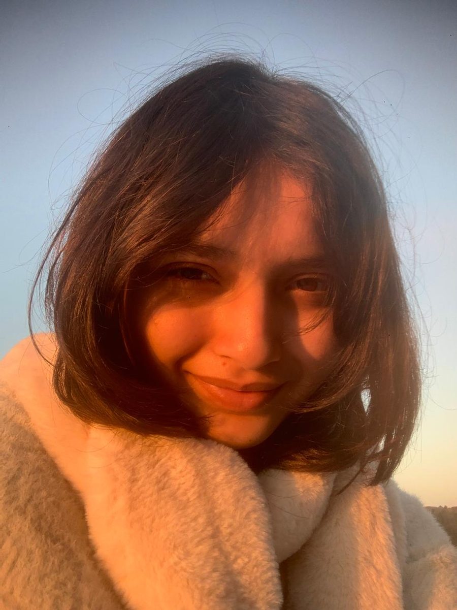 Moksha Sisodiya, founder of Moon Society, smiling in golden evening light
